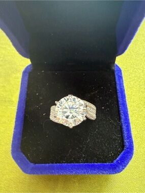 5 CT moissanite stone set in silver looking ring maybe about a size 5.